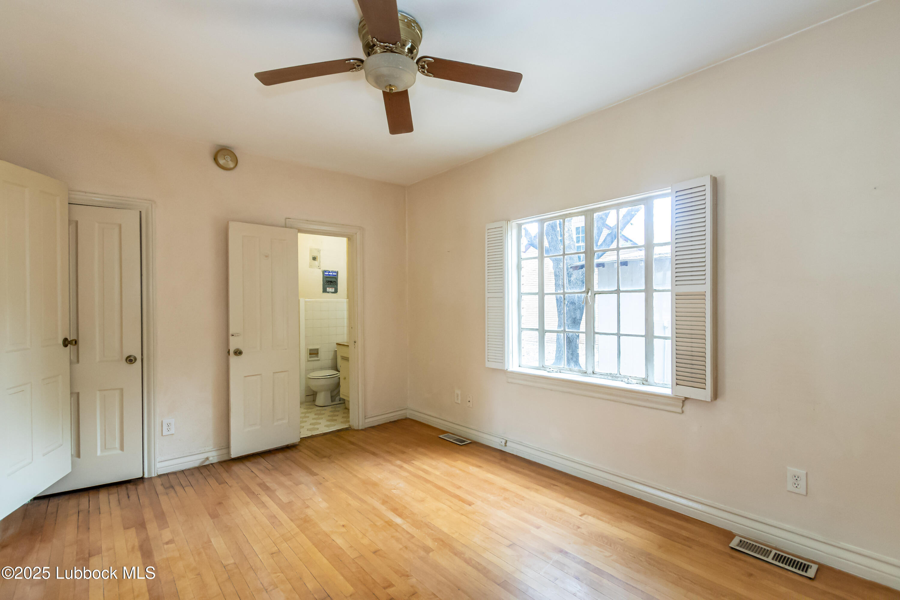 2324 17th Street Lubbock, TX 79401 - Photo 16 of 34 a view of an empty room with wooden floor and a window