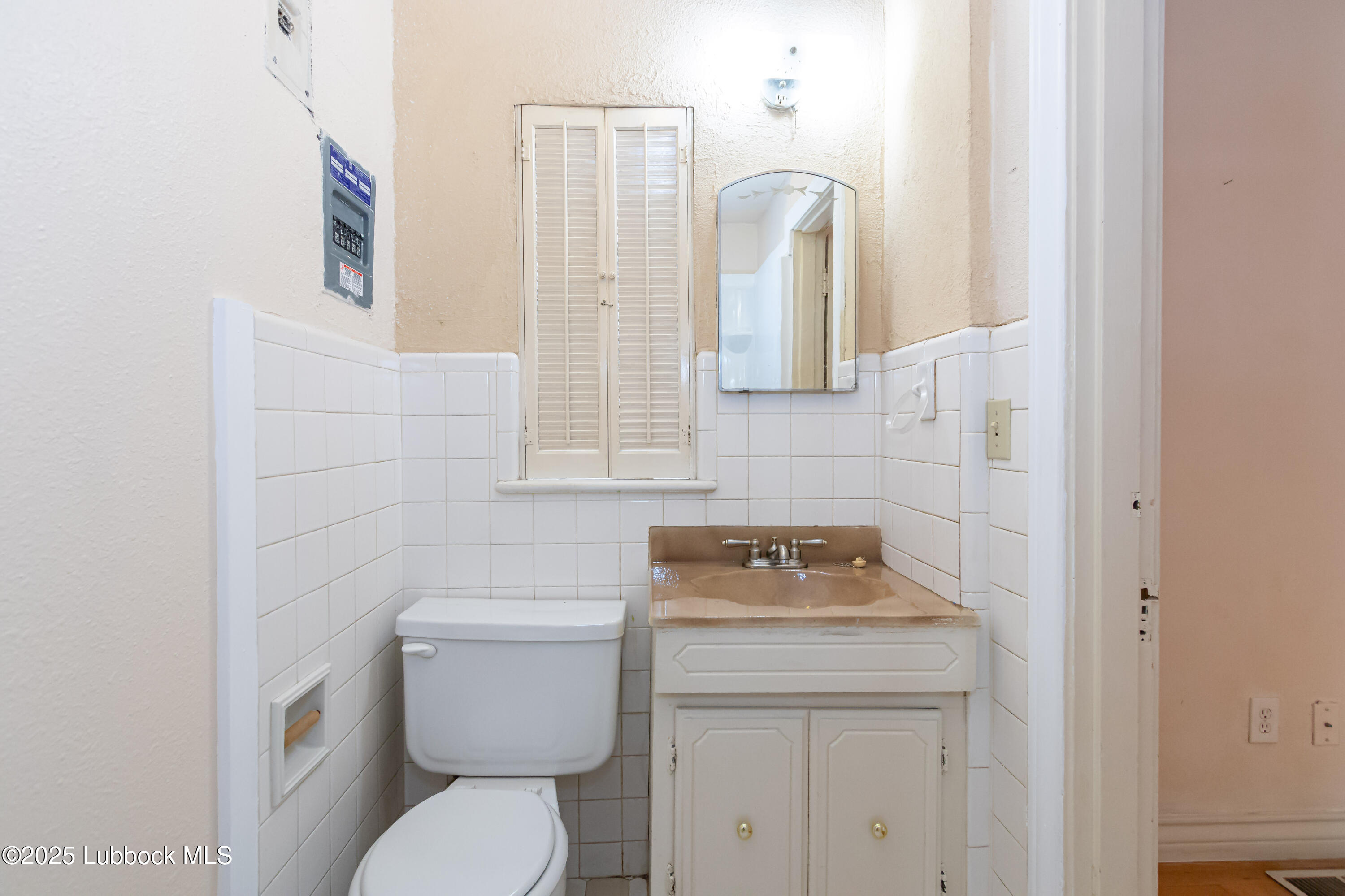 2324 17th Street Lubbock, TX 79401 - Photo 19 of 34 a bathroom with a toilet sink and mirror
