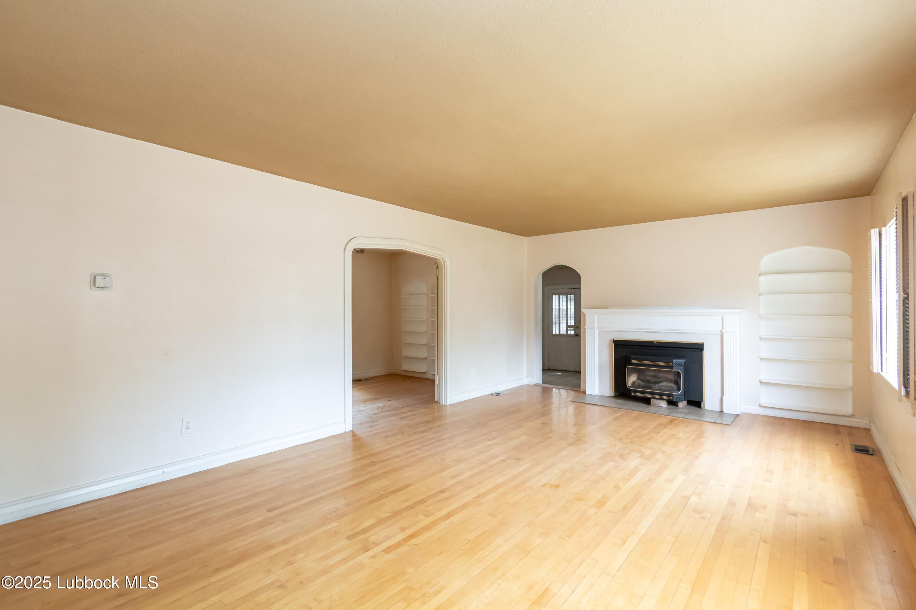 2324 17th Street Lubbock, TX 79401 - Photo 2 of 34 a view of an empty room with a fireplace and a window