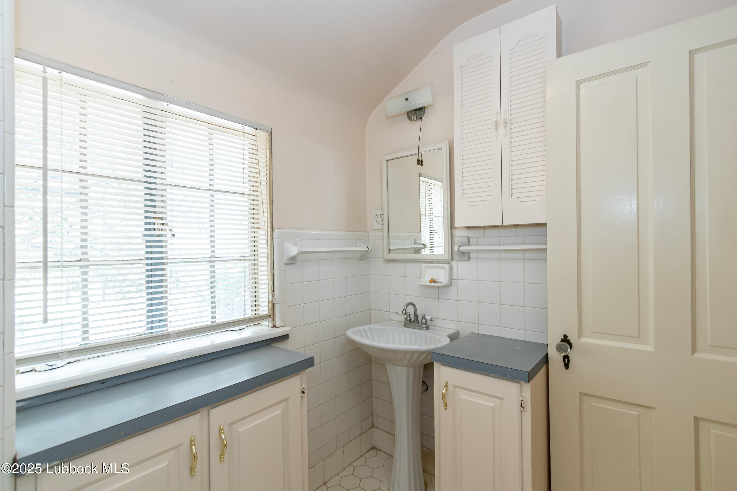 2324 17th Street Lubbock, TX 79401 - Photo 28 of 34 a bathroom with a sink and a window