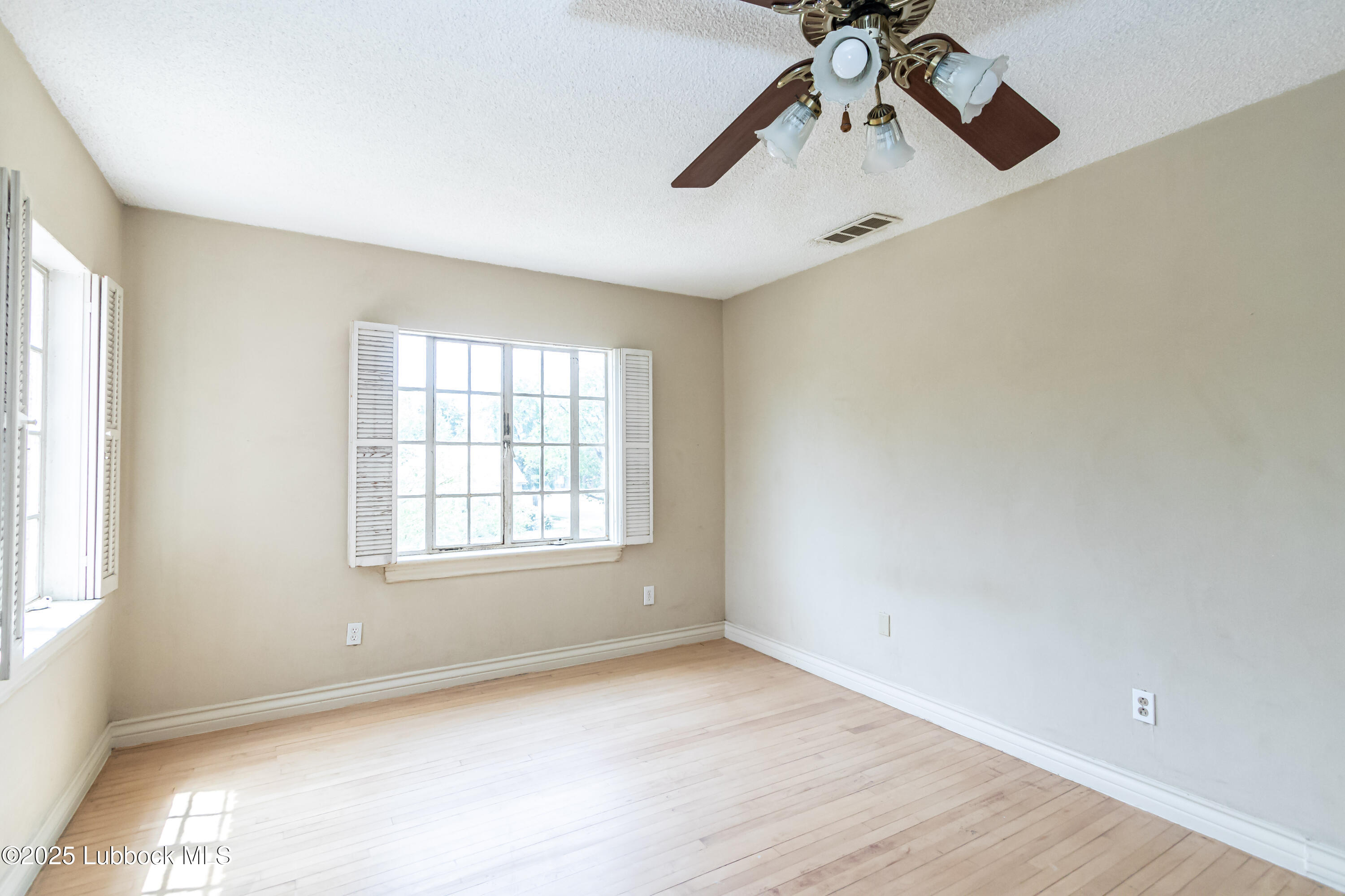 2324 17th Street Lubbock, TX 79401 - Photo 29 of 34 an empty room with chandelier fan and windows