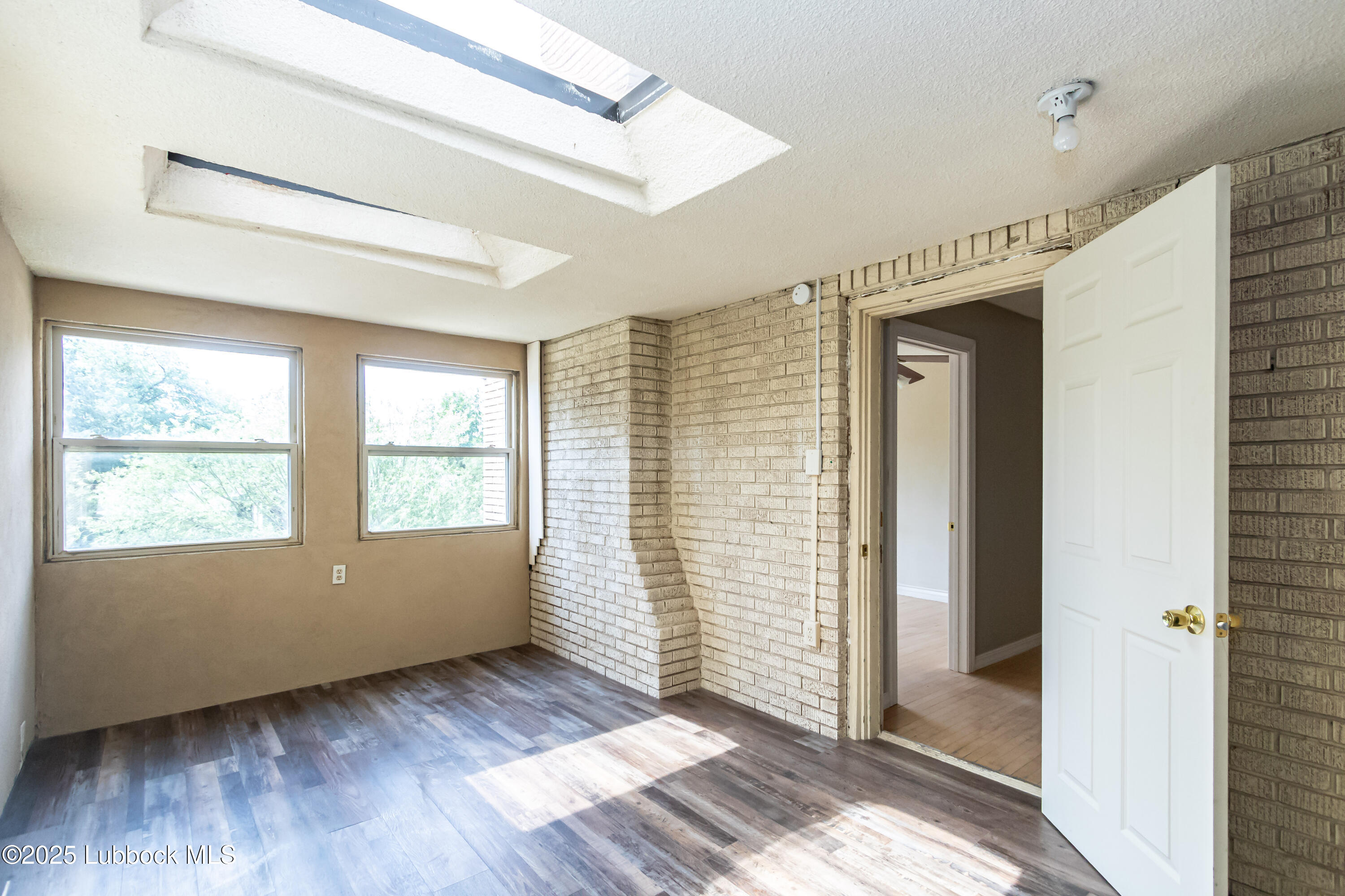 2324 17th Street Lubbock, TX 79401 - Photo 31 of 34 a view of an empty room with wooden floor and a window