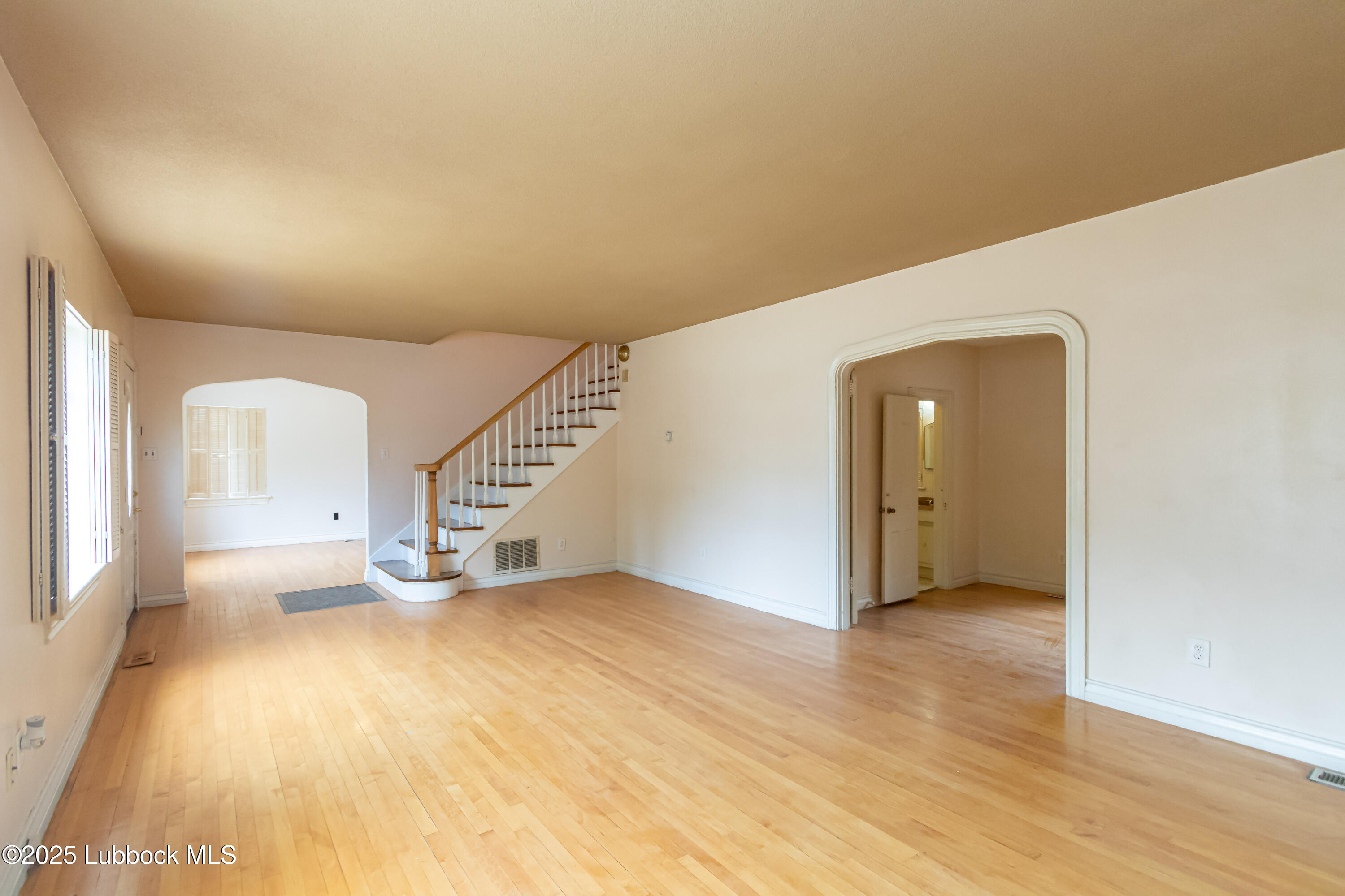 2324 17th Street Lubbock, TX 79401 - Photo 4 of 34 a view of an empty room with wooden floor and a window