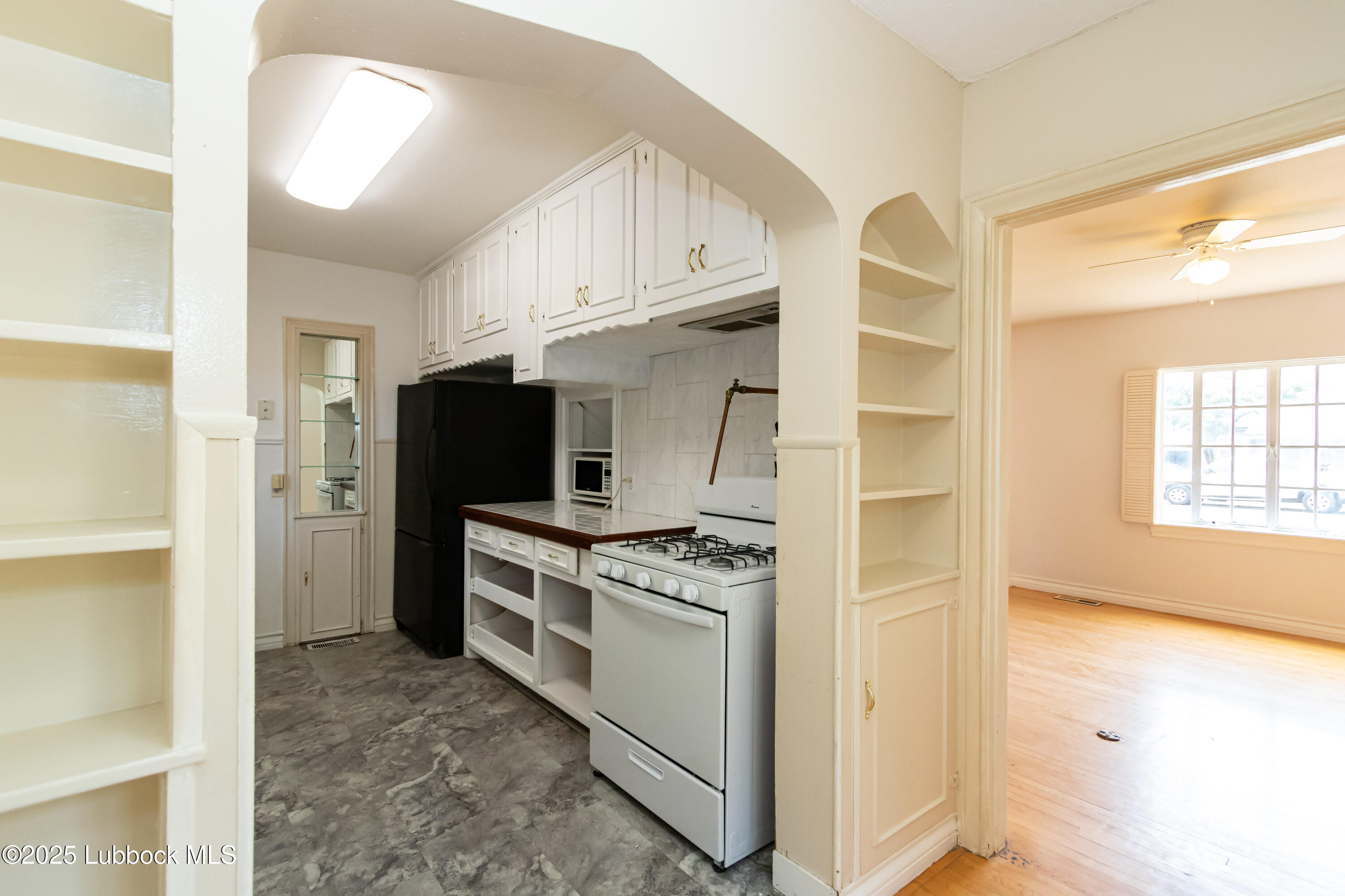 2324 17th Street Lubbock, TX 79401 - Photo 9 of 34 a kitchen with stainless steel appliances granite countertop a stove and a refrigerator