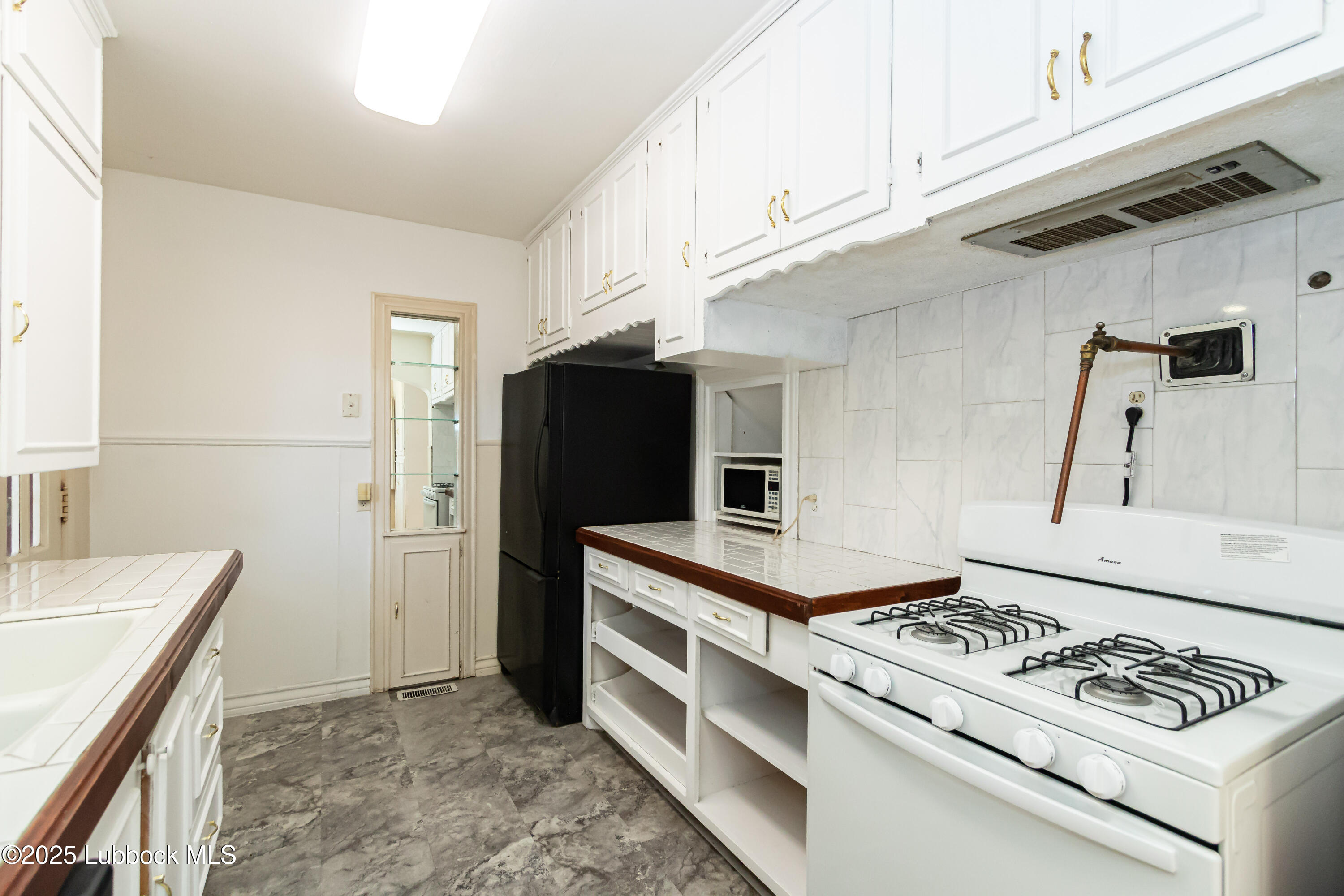 2324 17th Street Lubbock, TX 79401 - Photo 10 of 34 a kitchen with stainless steel appliances granite countertop a stove and a refrigerator