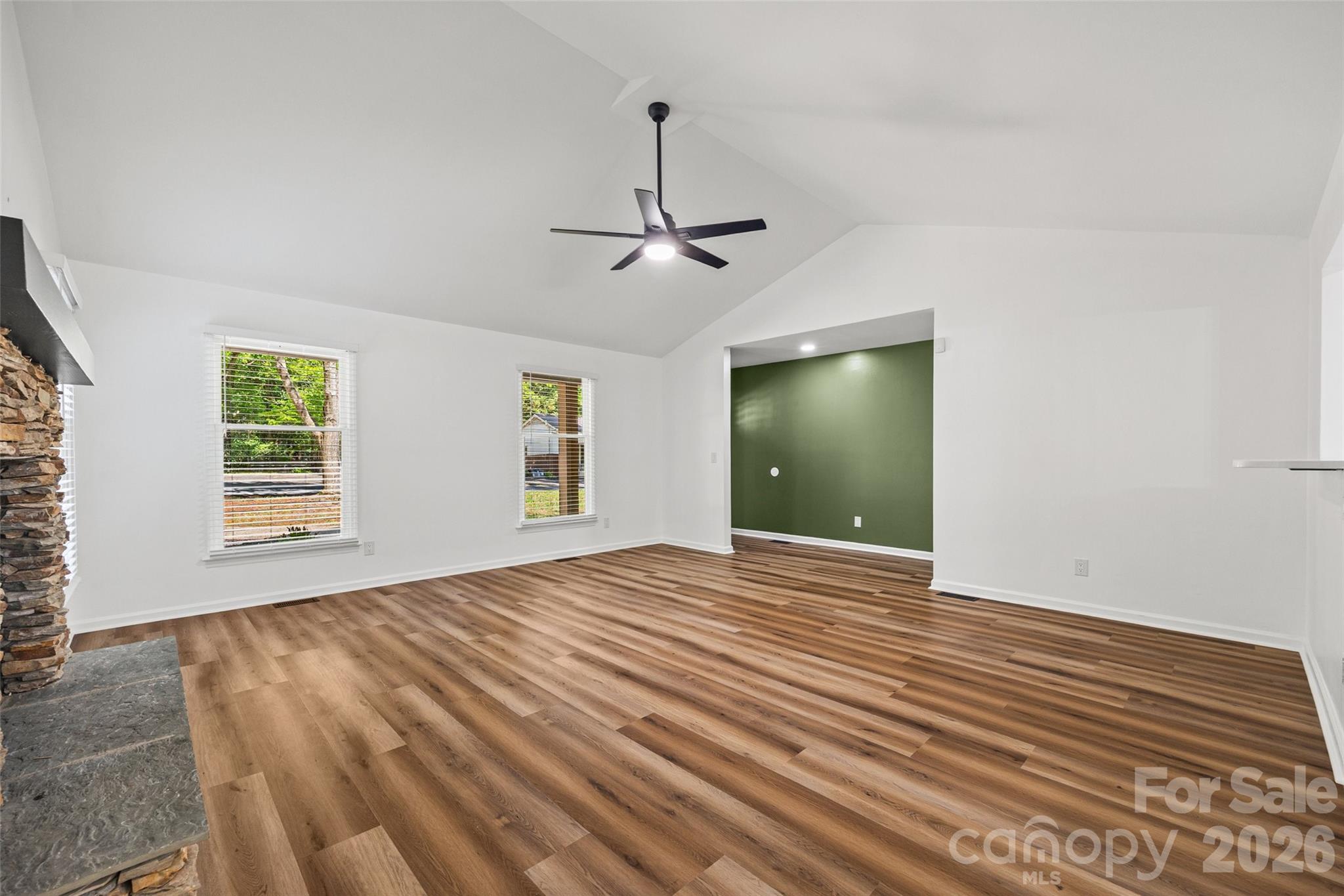 5043 Suwarrow Circle Tega Cay, SC 29708 - Photo 5 of 22 an empty room with wooden floor ceiling fan and windows