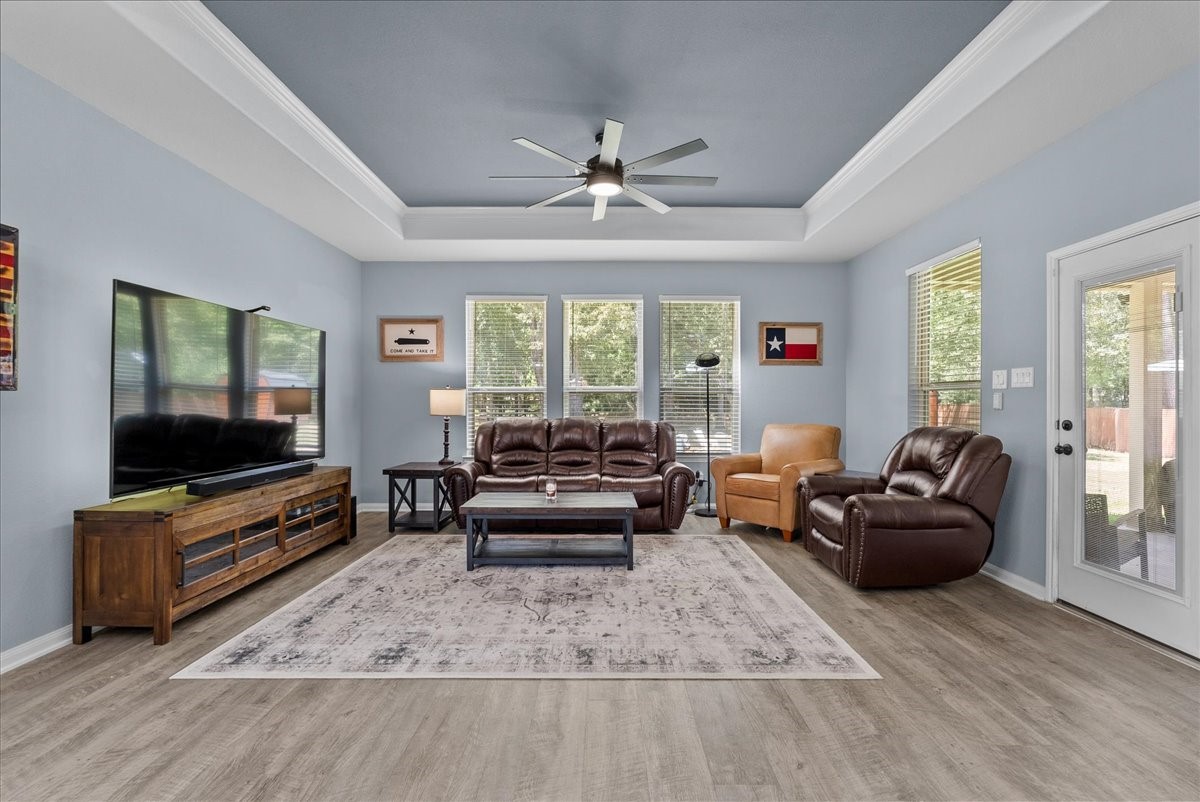 Relax and unwind in the inviting family room featuring a beautiful tray ceiling and abundant natural light.