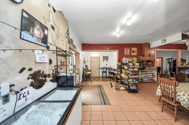 a kitchen with stainless steel appliances kitchen island granite countertop a refrigerator a stove a sink dishwasher and white cabinets with wooden floor