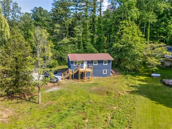 an aerial view of a house with a yard swimming pool and outdoor seating