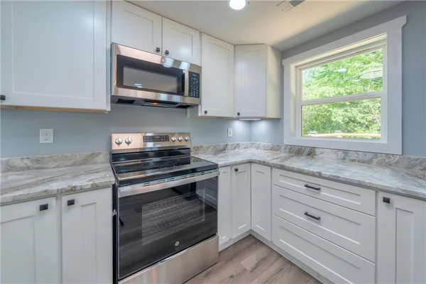 a kitchen with stainless steel appliances granite countertop a stove and a microwave