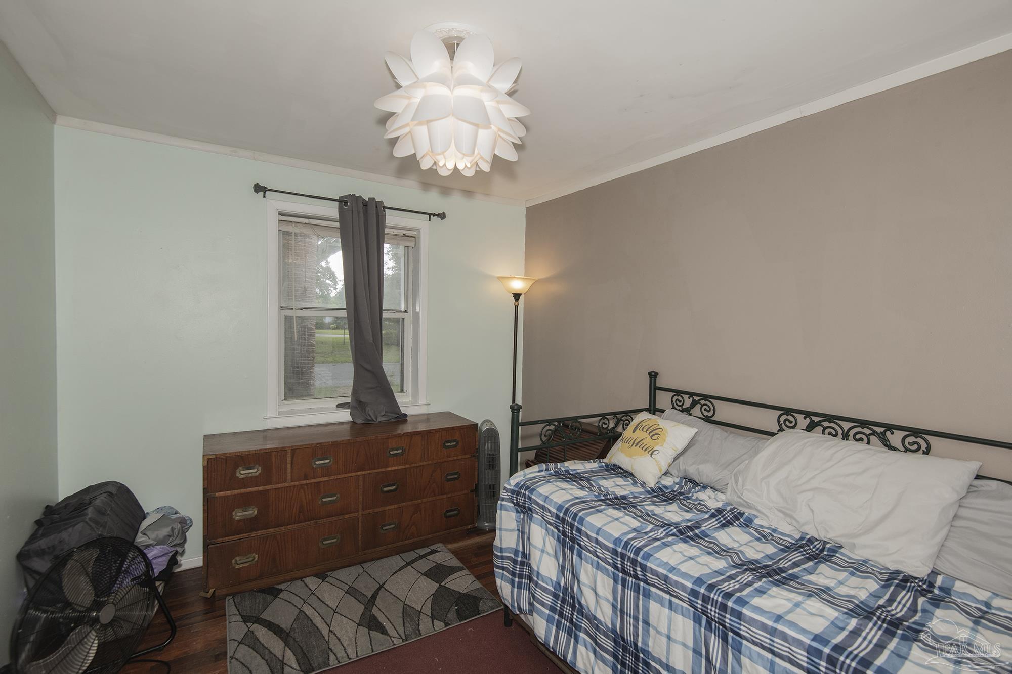 5921 Prince Road Pensacola, FL 32503 - Photo 12 of 22 a bedroom with a bed and a chandelier