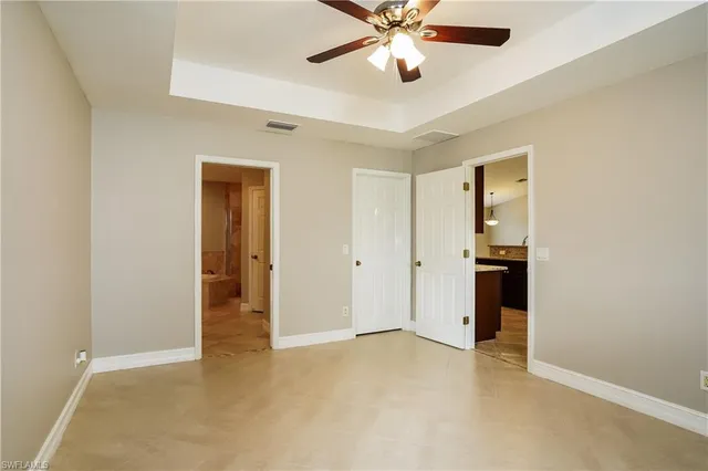 an empty room with closet and a ceiling fan