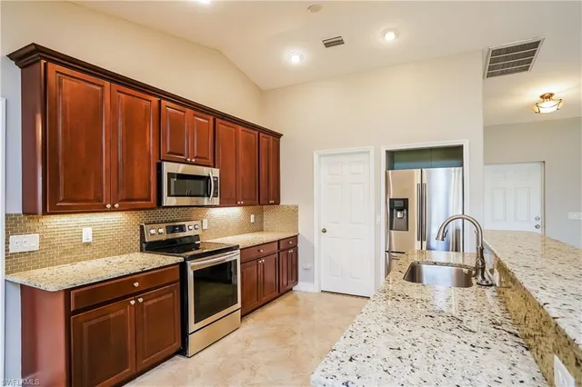 a kitchen with stainless steel appliances granite countertop a stove sink and microwave