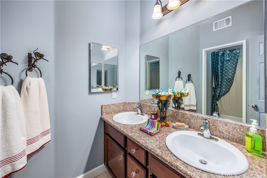 47298 Twin Pines Road Banning, CA 92220 - Photo 43 of 65 a bathroom with 2 sink and a mirror