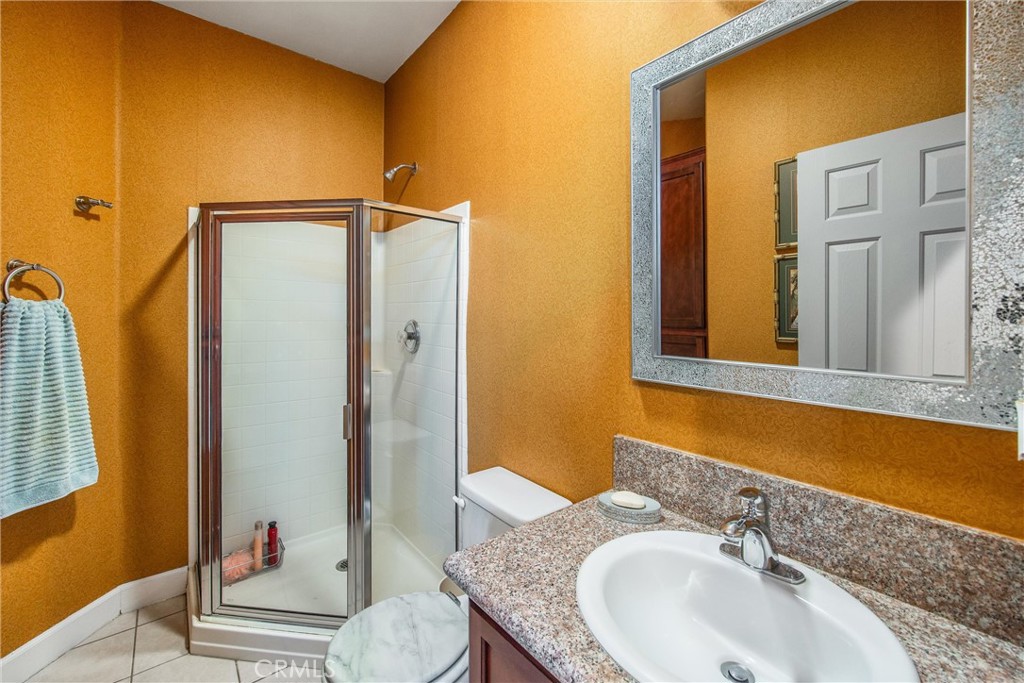 47298 Twin Pines Road Banning, CA 92220 - Photo 45 of 65 a bathroom with a granite countertop sink and a mirror