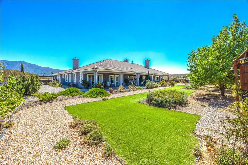 47298 Twin Pines Road Banning, CA 92220 - Photo 61 of 65 a view of a house with a yard table and chairs