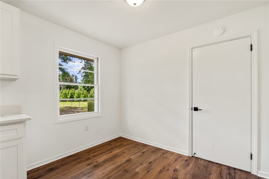300 Vandiver Road Anderson, SC 29621 - Photo 12 of 30 A well-lit room with warm wood flooring and a refreshing window view of lush greenery.