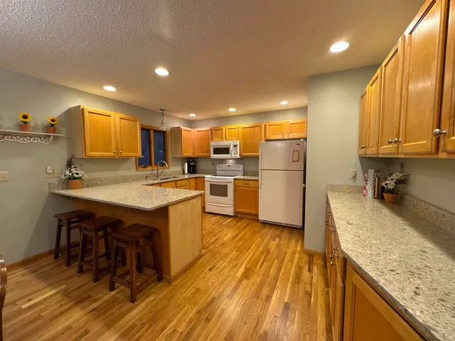 a kitchen with wooden floors and wooden cabinets