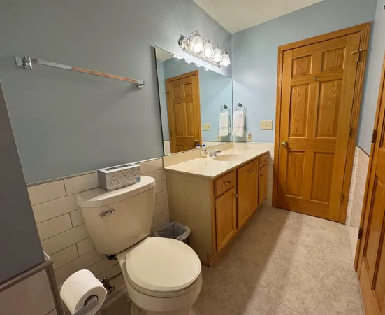 a bathroom with a sink and mirror with toilet