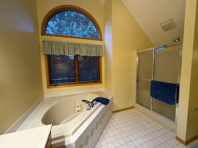 a bathroom with a tub and a chair