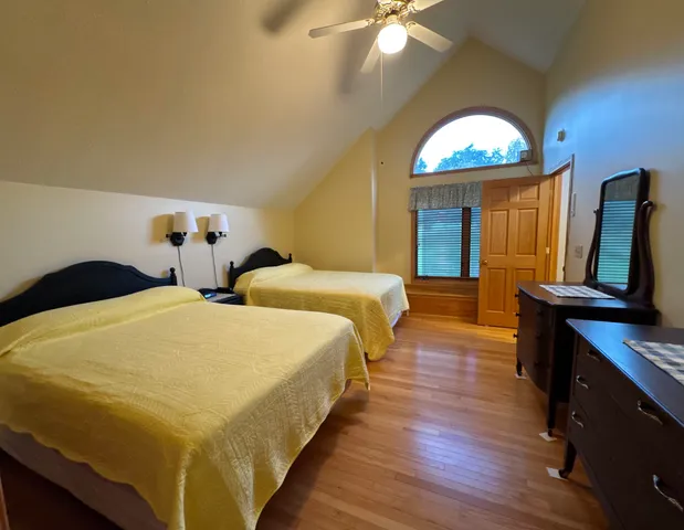 a spacious bedroom with two beds and a flat screen tv