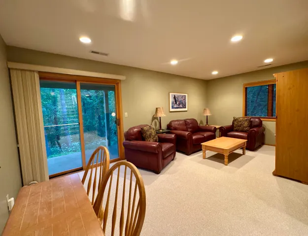 a living room with furniture two large windows and a chandelier