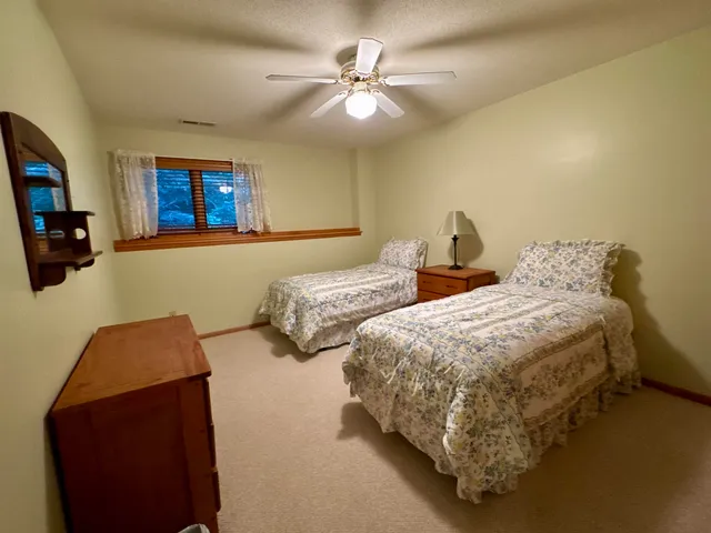a bedroom with two beds and a chandelier