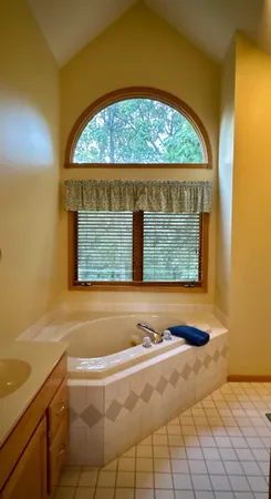a living room with furniture two large windows and a chandelier
