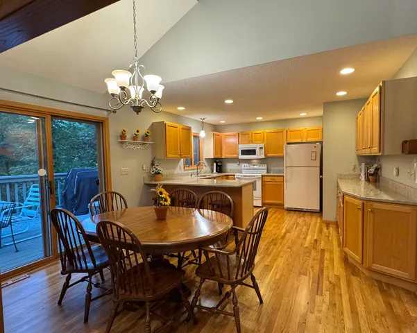 a dining room filled chandelier and wooden floor