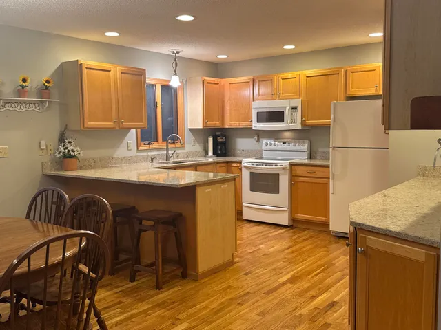 a kitchen with kitchen island a stove a sink a refrigerator and grey cabinets