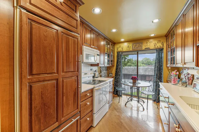 a kitchen with kitchen island wooden cabinets and refrigerator