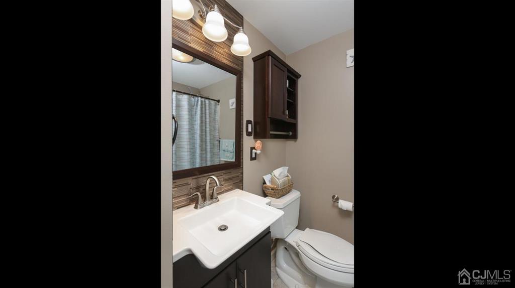 174 South Hill Road Colonia, NJ 07067 - Photo 20 of 31 a bathroom with a sink a toilet a mirror and vanity