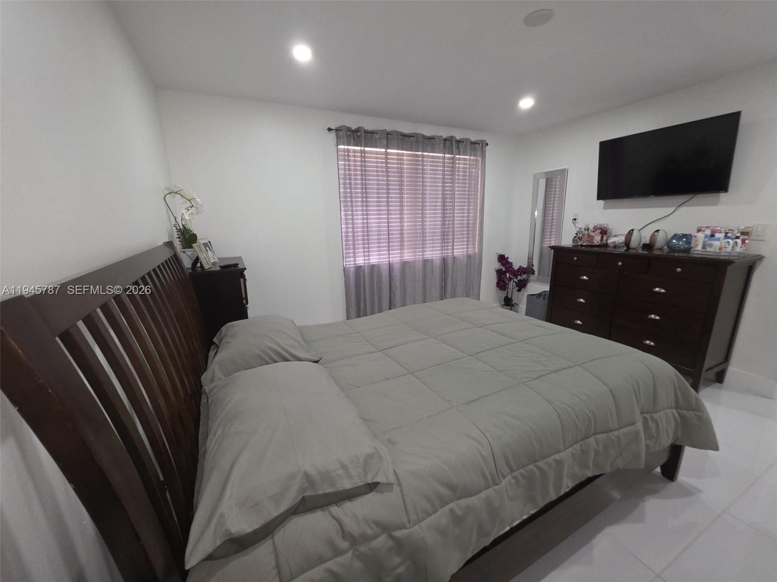 6970 Northwest 186th Street, Unit 3307 Hialeah, FL 33015 - Photo 12 of 21 a bedroom with a bed and a flat screen tv