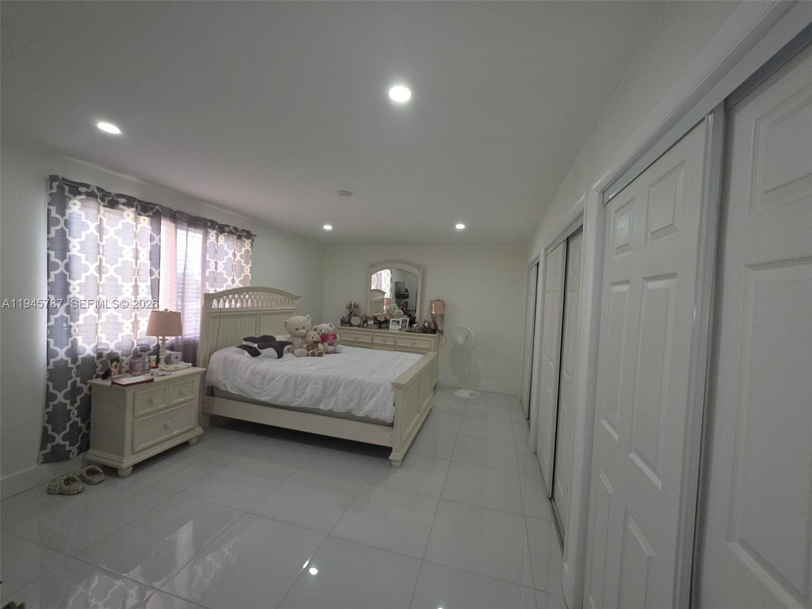 6970 Northwest 186th Street, Unit 3307 Hialeah, FL 33015 - Photo 13 of 21 a spacious bedroom with a bed and large window