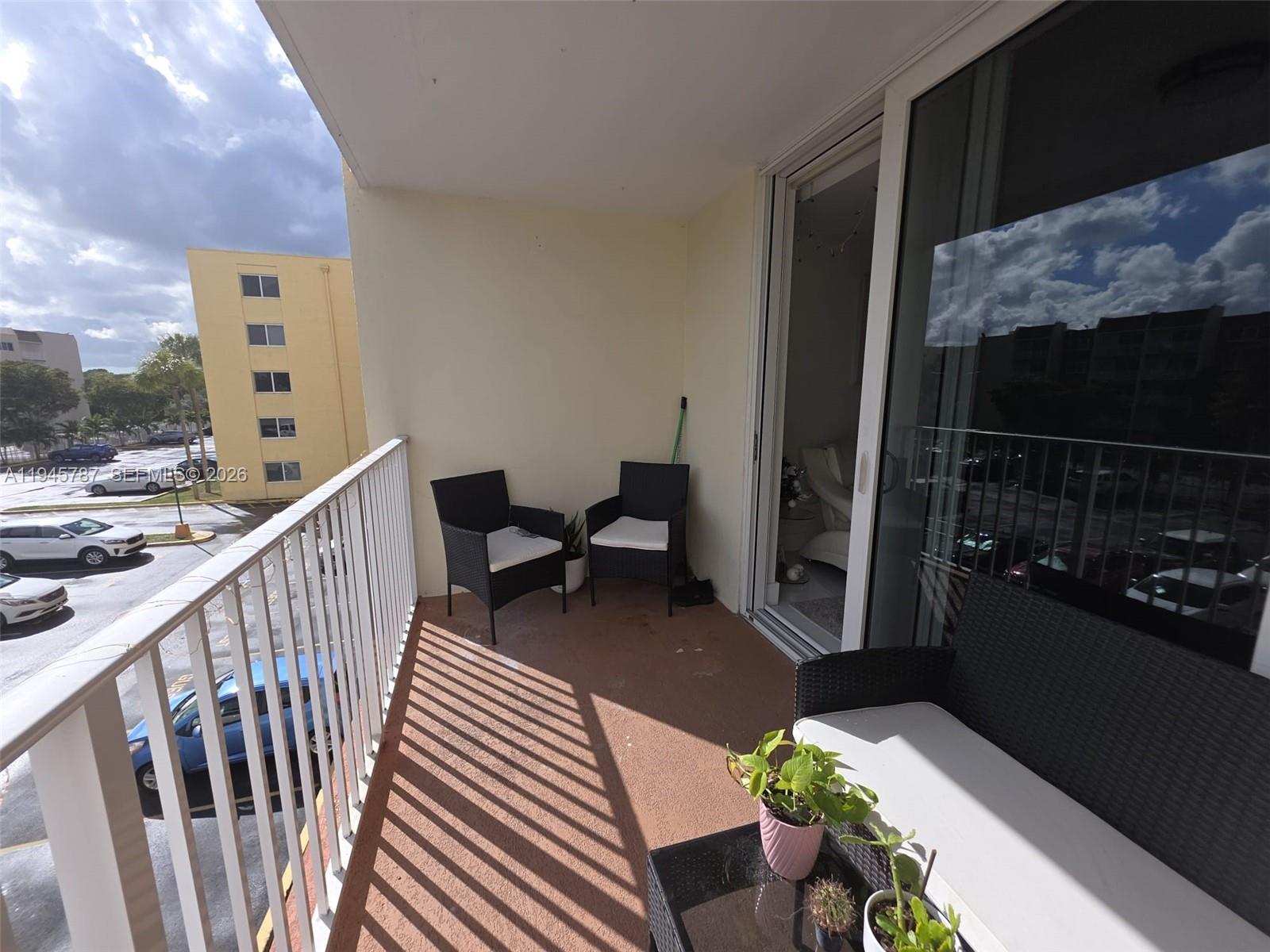 6970 Northwest 186th Street, Unit 3307 Hialeah, FL 33015 - Photo 20 of 21 a balcony with furniture and a potted plant