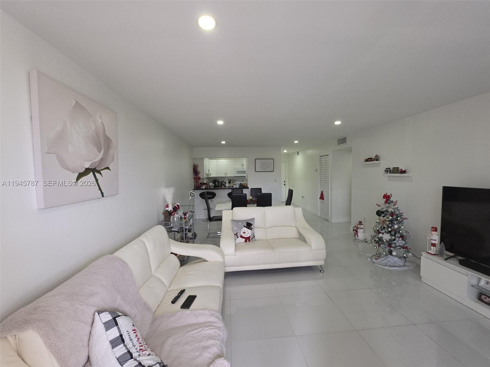 6970 Northwest 186th Street, Unit 3307 Hialeah, FL 33015 - Photo 2 of 21 a living room with furniture and a flat screen tv