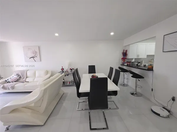 a living room with furniture a flat screen tv and a table