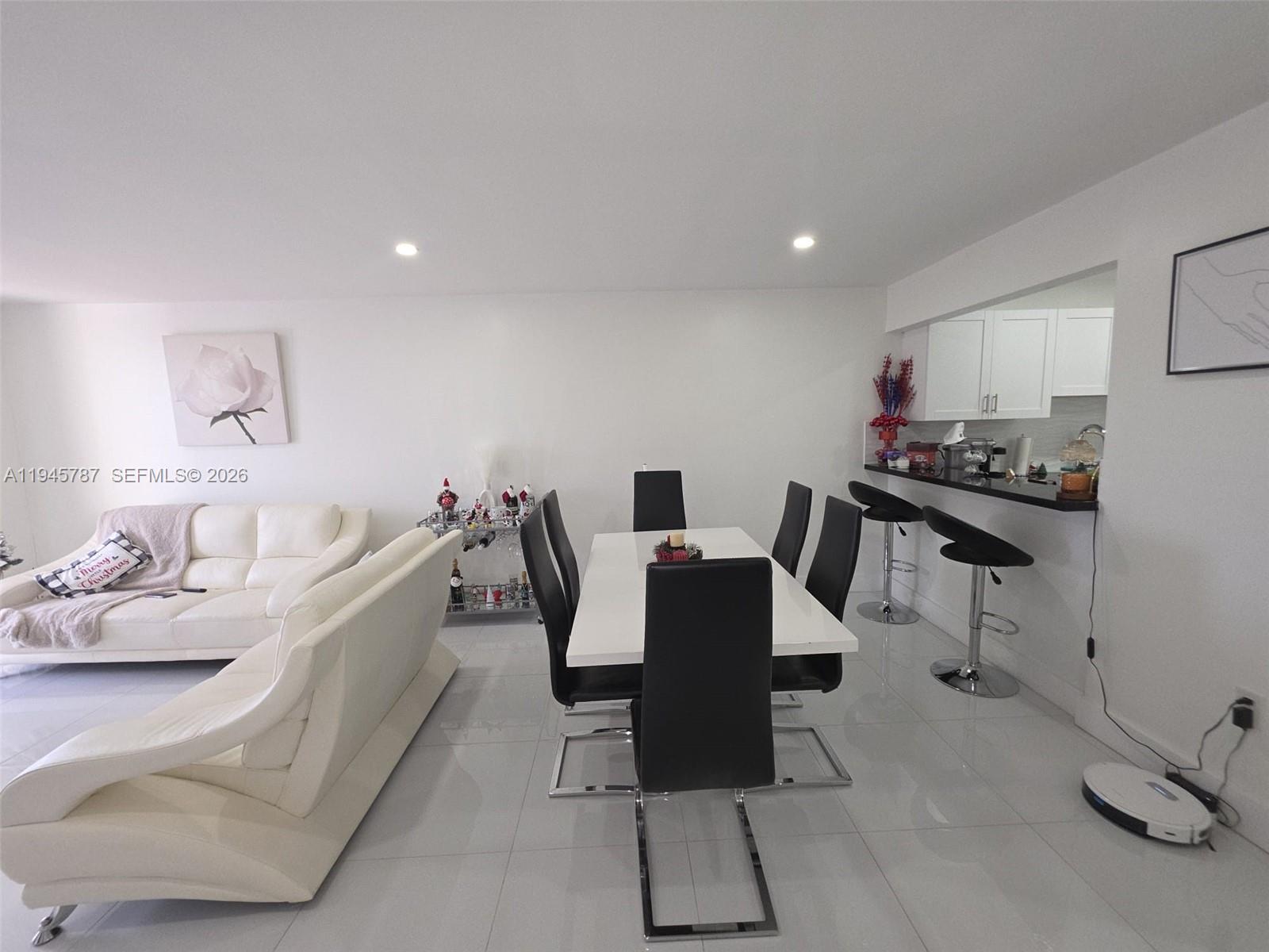 6970 Northwest 186th Street, Unit 3307 Hialeah, FL 33015 - Photo 7 of 21 a living room with furniture a flat screen tv and a table