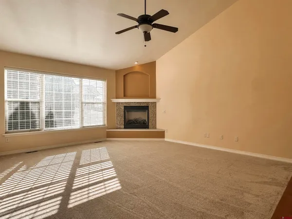 a view of an empty room with a fireplace and a window