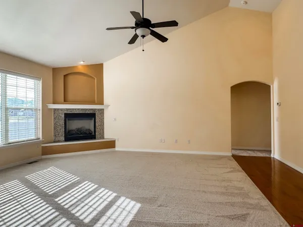 a view of an empty room with a fireplace and a window
