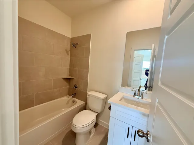 a bathroom with a granite countertop toilet a sink and a bathtub