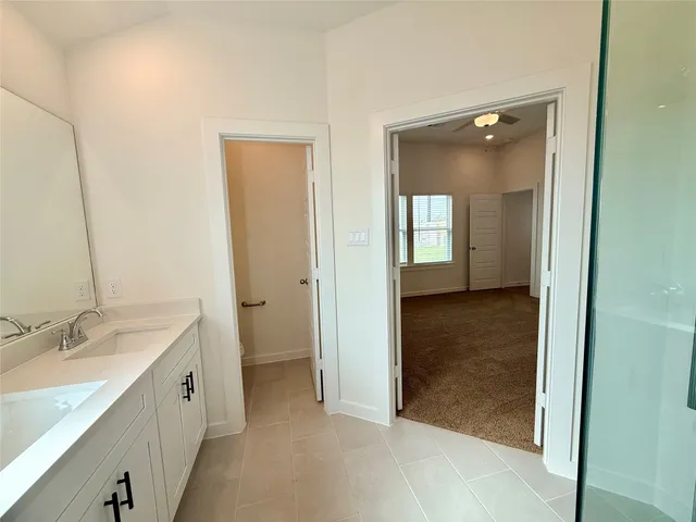 an empty room with a window and a ceiling fan