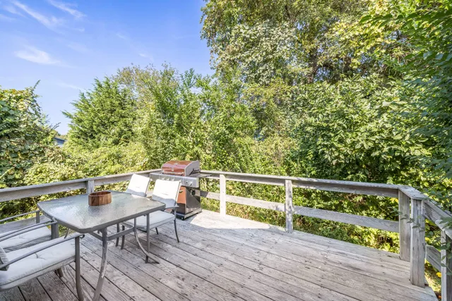 a balcony with wooden floor table and chairs
