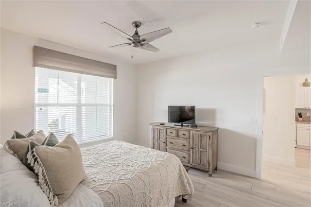 a bedroom with a bed a chandelier and a window