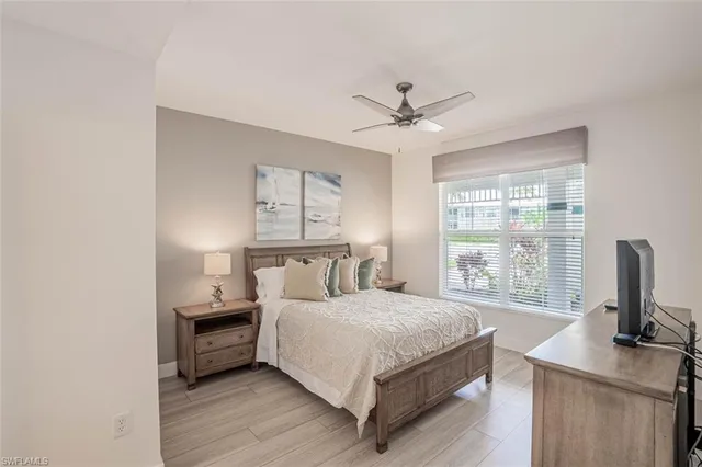 a bedroom with a bed flat screen tv and a large window