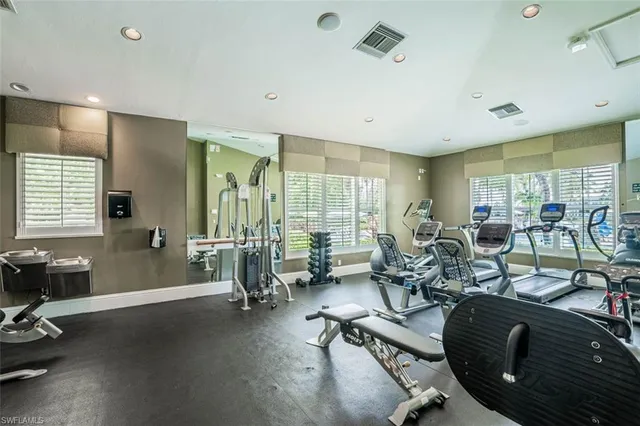 a gym room with lots of chairs and mirrors
