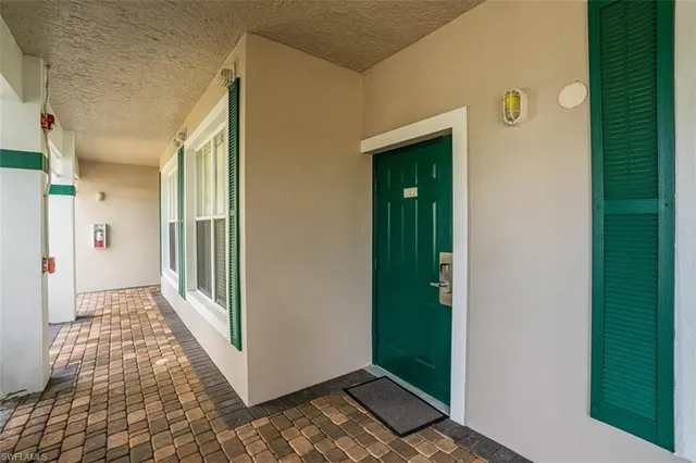 a view of a hallway with wooden floor and a livingroom