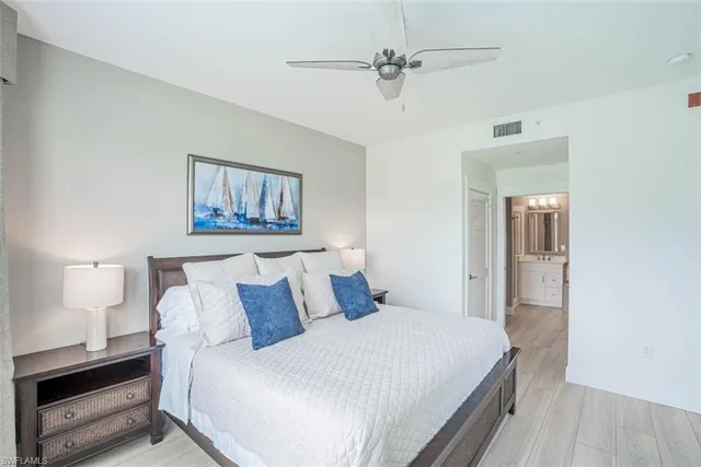 a bedroom with a large bed and a chandelier