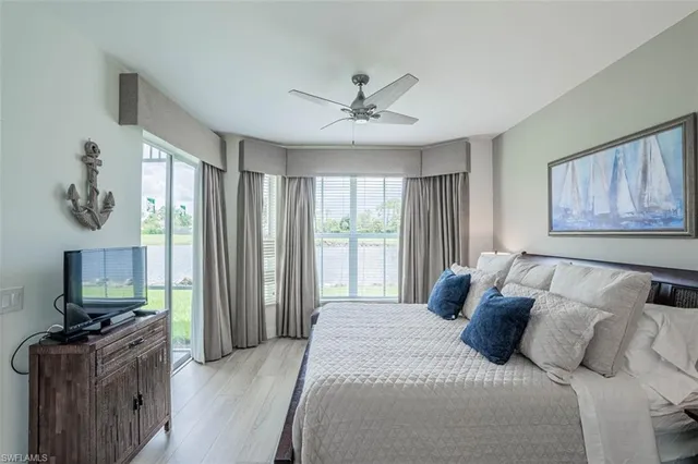 a bedroom with a large bed and a flat tv screen