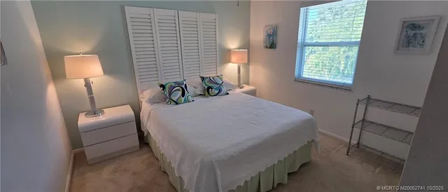 a bed with a white comforter and chair